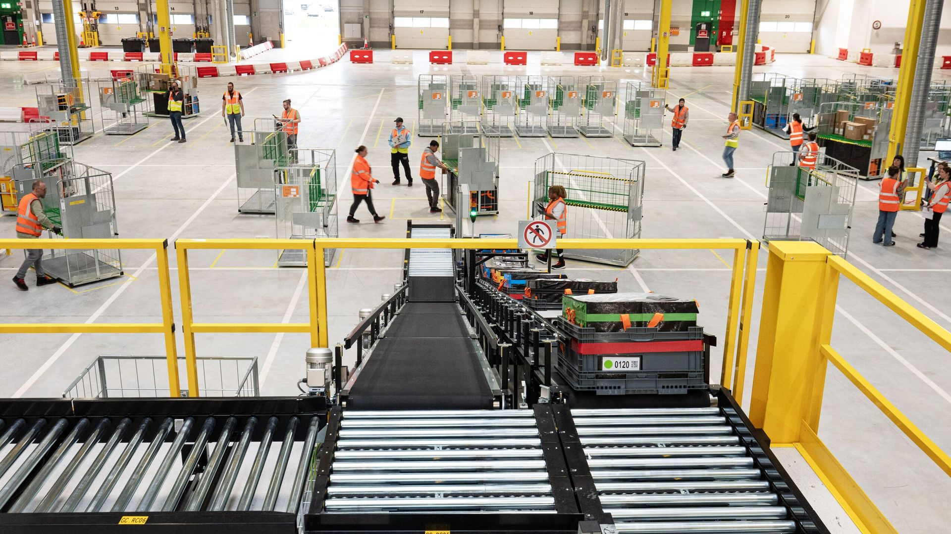 Amazon fulfillment center showing staff and automated sorting equipment with global same-day delivery coverage
