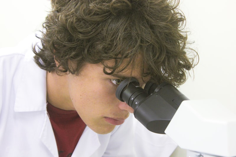 Scientist Examining Samples Under Microscope in Genetics Research Lab