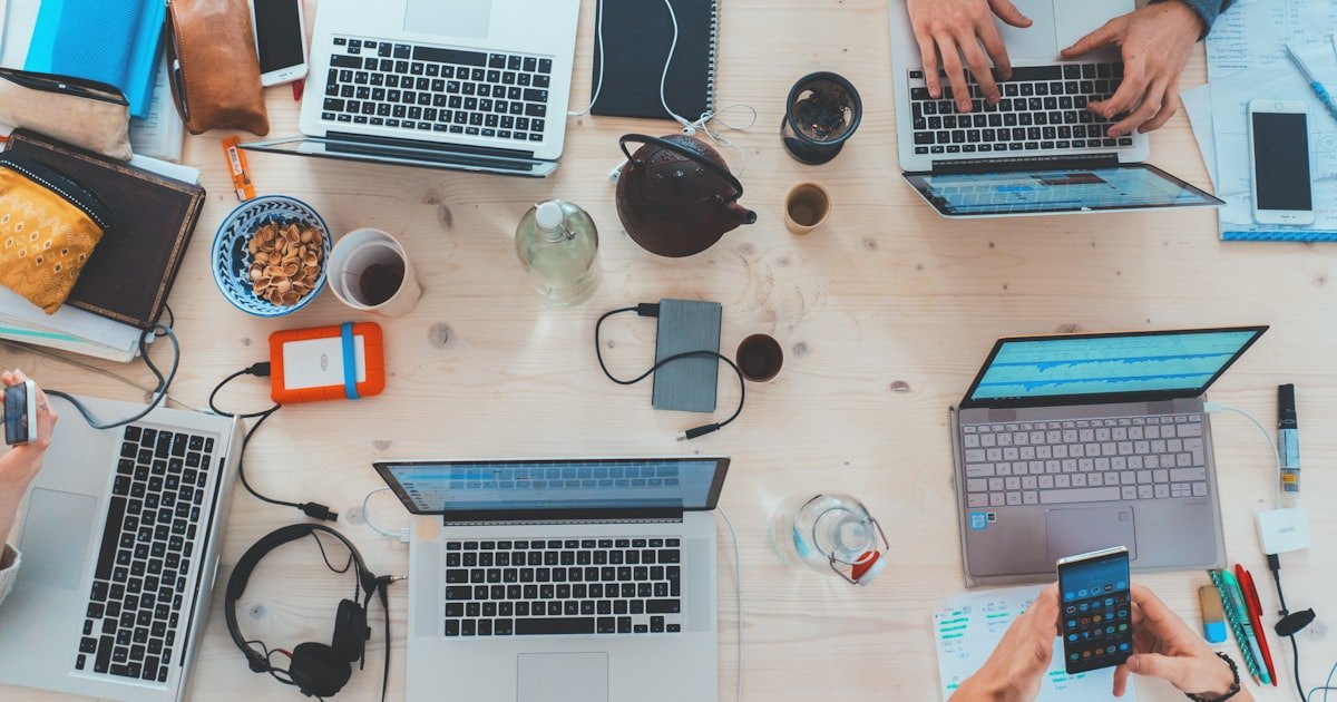 Colleagues working together on laptops around a table
