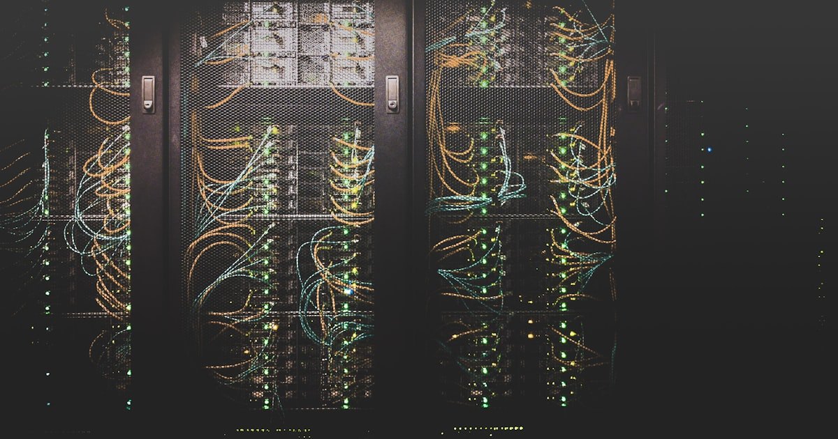 Bundles of network cables and patch cords routed into equipment racks in a dimly lit server room